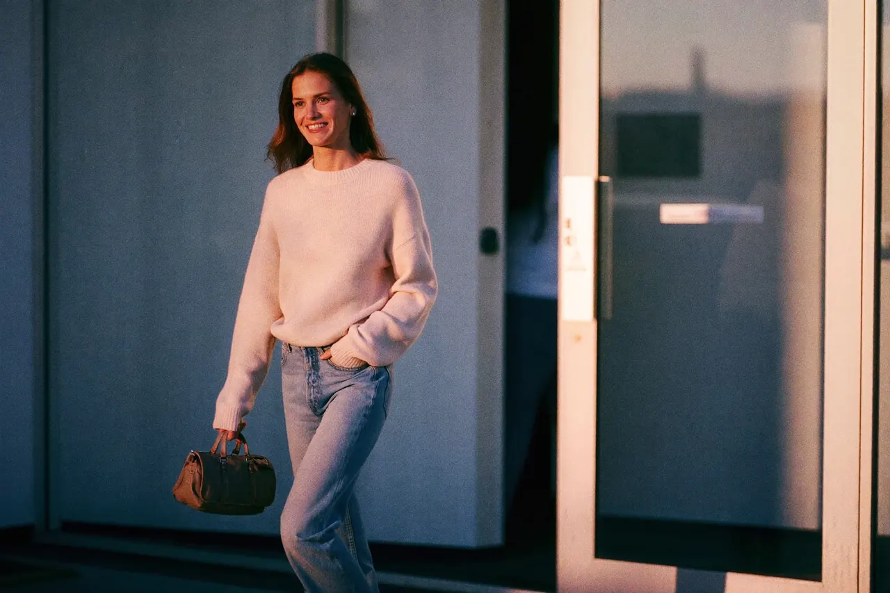 A smiling woman walking out of a clinic into warm morning light